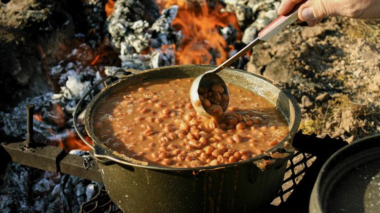 Crockpot baked beans near campfire