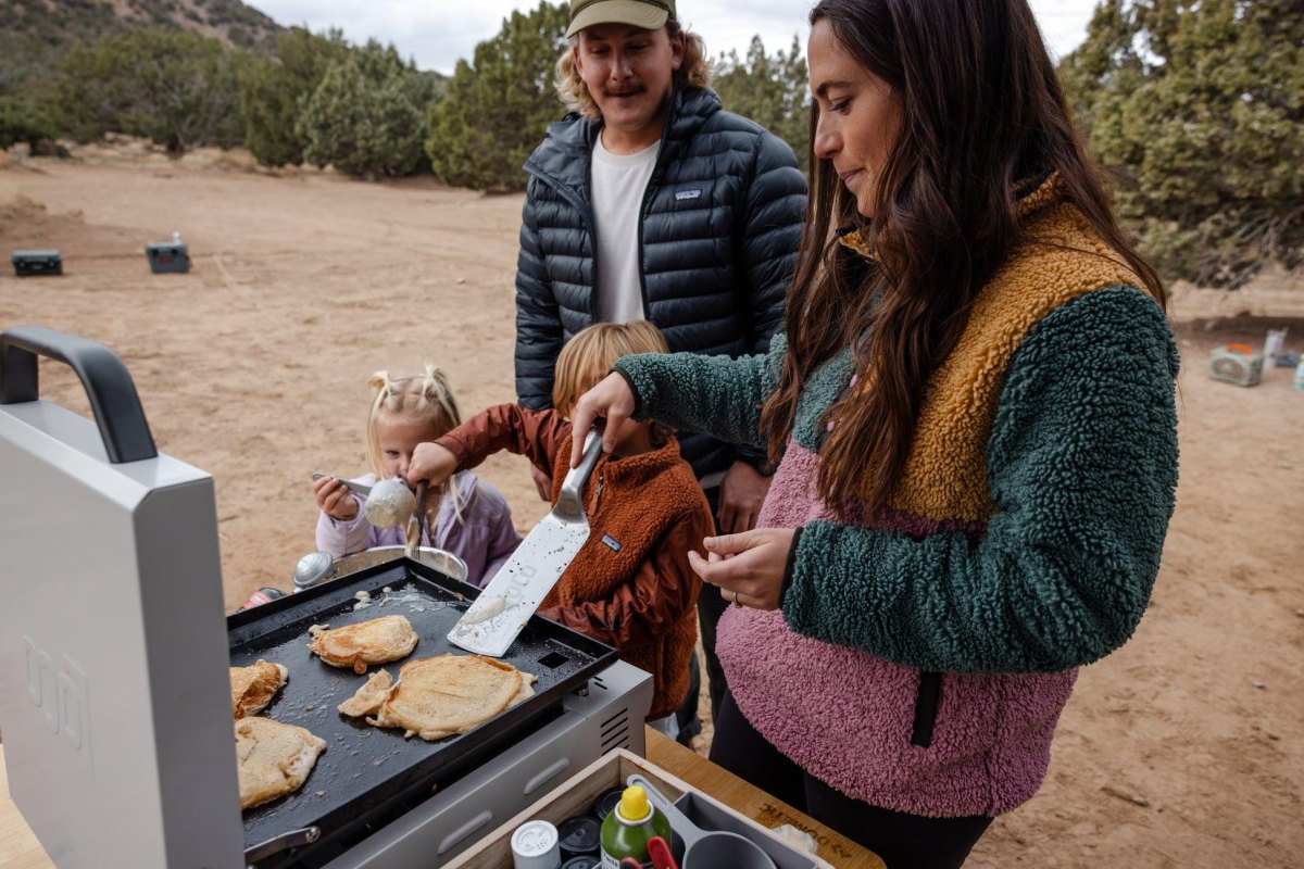Family cooking pancakes at campsite