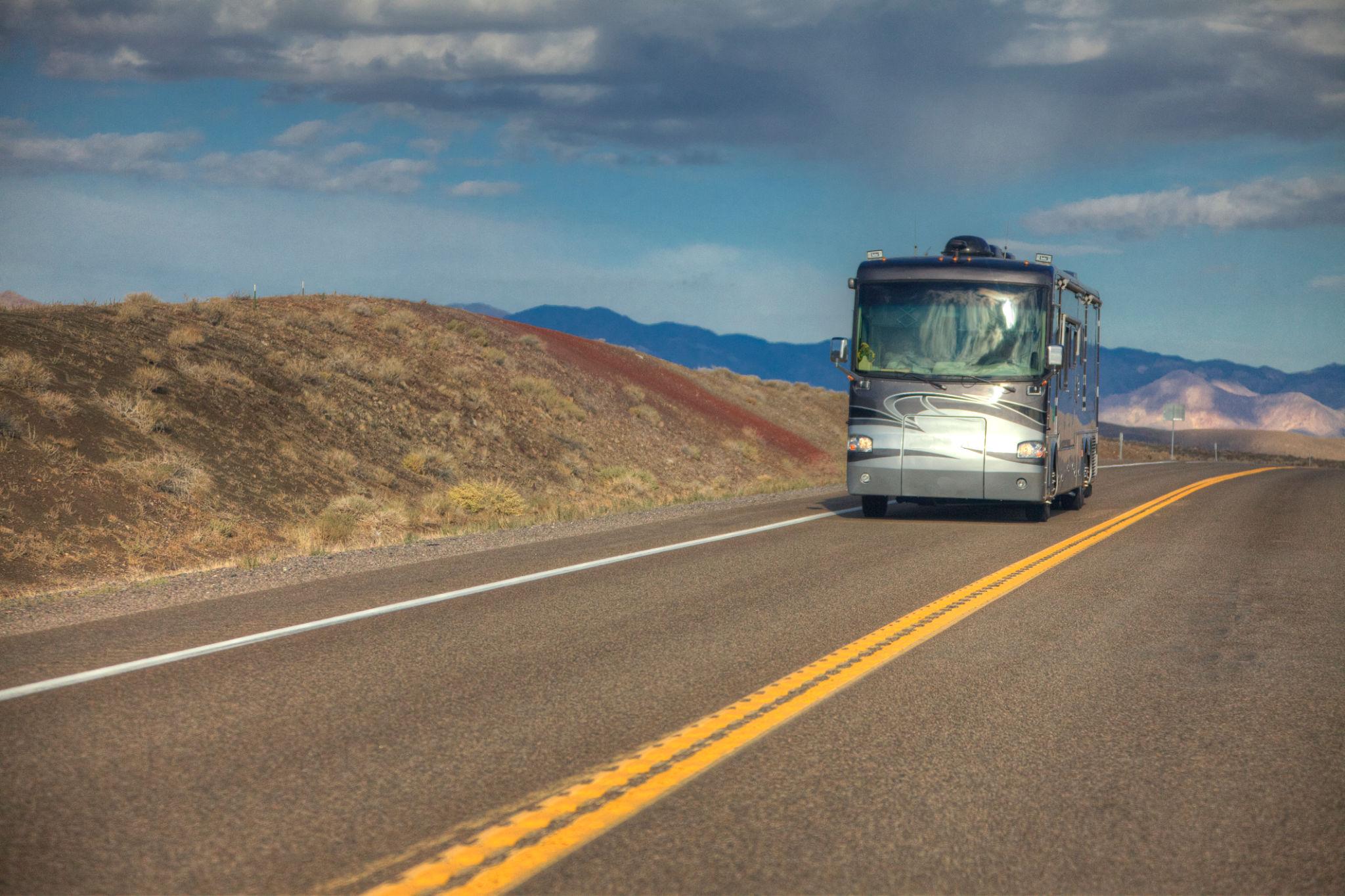 Motorhome driving on a highway showing fuel costs for full time RV living