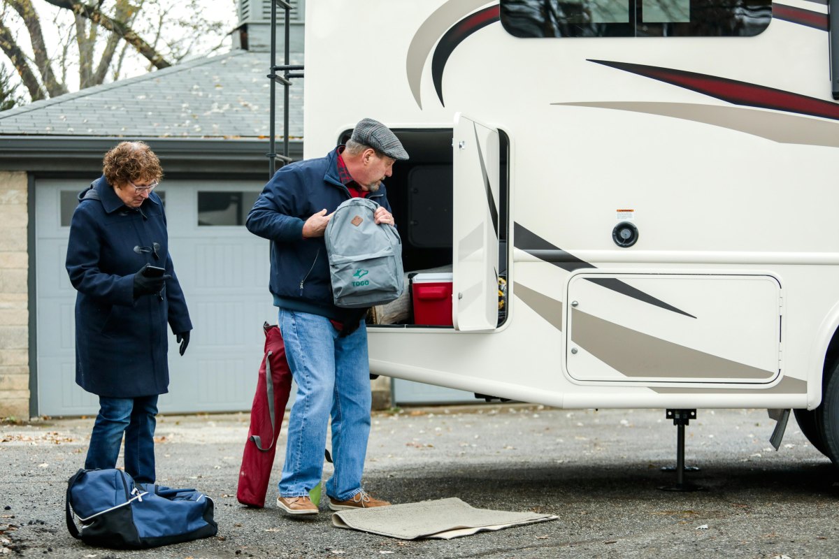 RV owner packing campsite before departure